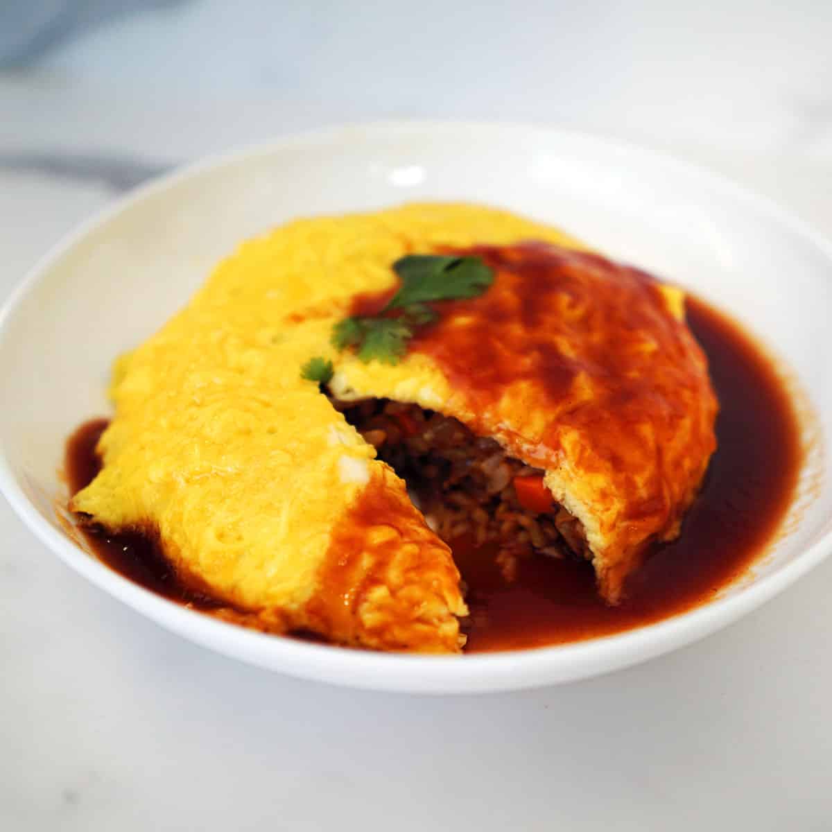 A photo of a plate of omurice drizzled in curry sauce